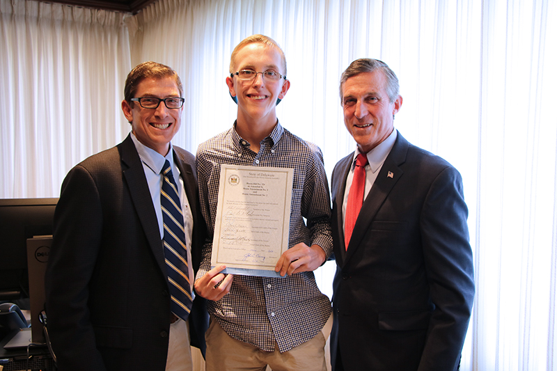 CDS Associate Director Brian Freedman, Cape Henlopen High School student Zach Simpler, and Gov. John Carney pose at bill signing