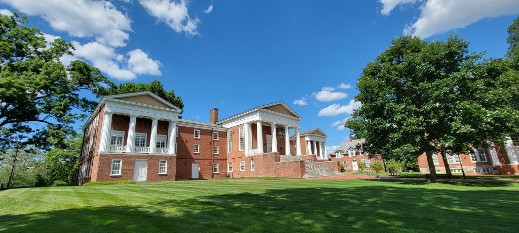 Old College at the University of Delaware on a sunny day across a bright green lawn.