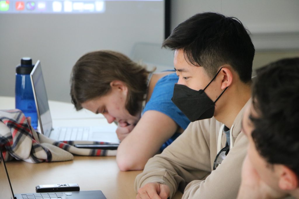 Three students sitting at a table during a group coaching session