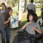 Artfest participant and volunteer admiring their creation