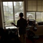 Boy with autism looks out his living room window