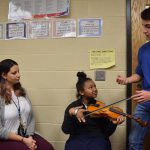 High school student offers Rayne Mason a violin lesson
