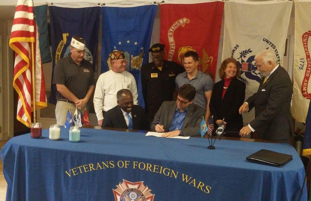 New Castle County Executive Matt Meyer, center, signs Ordinance 18-018 into effect