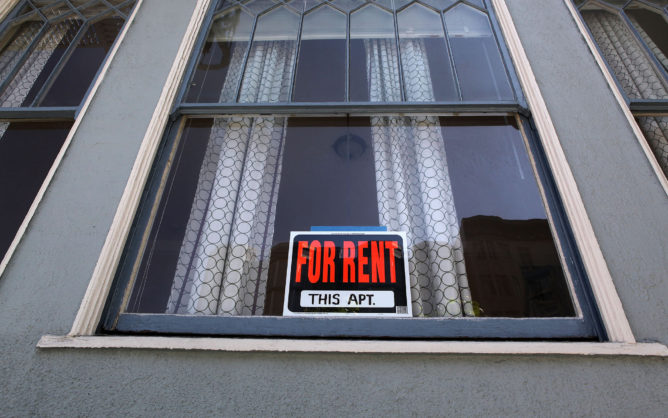 For Rent sign in apartment window