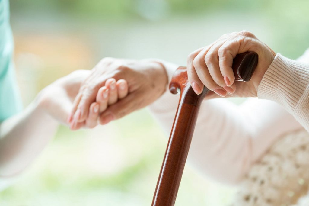 A person's hand holds a can while the other takes the hand of a helper