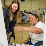 At Artfest 2018, UD student volunteer Chloe Weissman (left) and participant Ebony Tucker admire a finished project. (Evan Krape / University of Delaware)