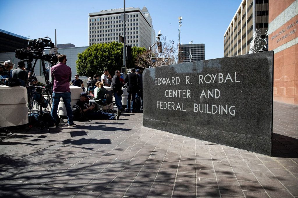 Journalists wait outside the Edward R. Roybal Center and Federal Building in Los Angeles
