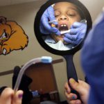 Child with disabilities gets teeth examined by dentist