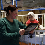 doctor looking at medical chart and child patient
