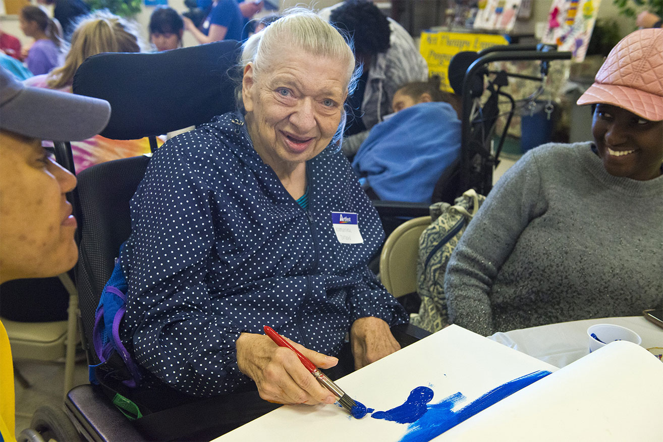 Katherine Ditlow smiles as she starts painting the ocean surrounding her tropical island paradise. At Artfest 2019, each participant got to paint a single canvas and take it home to display. 