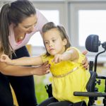 A caregiver helps a child with a disability