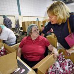 A sheltered workshop employee takes a momentary break from repackaging plastic sprayers to chat with her mother.