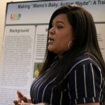 LEND trainee Kendra Haynes stands before her poster she designed while delivering a presentation to fellow graduates and advisers