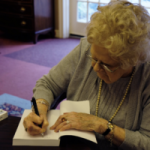 Author Jacqueline Gellens Watson signs a copy of her book The Habit