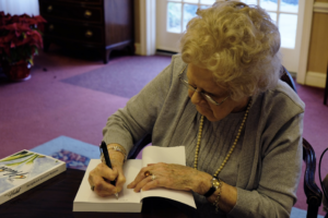 Author Jacqueline Gellens Watson signs a copy of her book The Habit