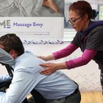 An Massage Envy employee gives a person a massage.