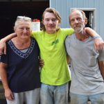 Phillip Hartman, center, stands with his parents Faith and Mark near their Laurel home.