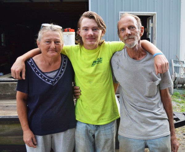 Phillip Hartman, center, stands with his parents Faith and Mark near their Laurel home.