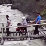 Wheel the World participant traversing river rapids