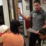 An uninsured woman takes her children in for a medical check-up at a low-cost clinic