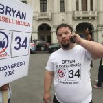 Bryan Russell takes a call as he campaigns for Congress in Lima, Peru.