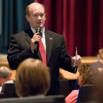 Senator Chris Coons addressing a room of people