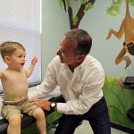 A doctor examines a 2-year-old