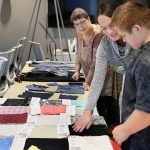 University of Delaware senior Elizabeth deBruin shows fabric swatches to 11-year-old Jayden Niblett of Seaford, Del., at the Innovation Health and Design Lab at the University of Delaware