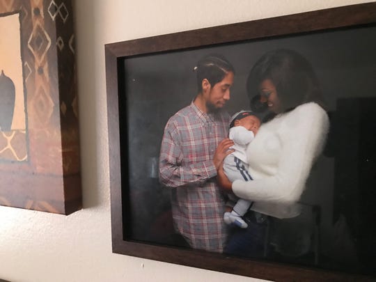 Photo hanging on a wall of Brandon Roberts (left) and Erica Jones with their son, Nasir.