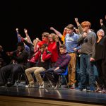 a group of teenagers and young adults who took part in Winging It perform improv in front of a crowd