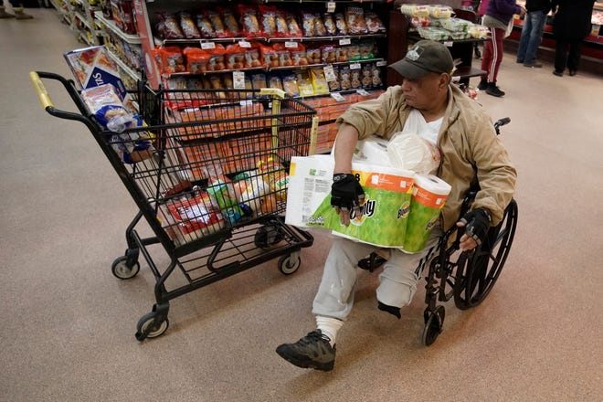 A shopper with disabilities navigates an isle at Northgate González Market on Tuesday, March 17, 2020, in Santa Ana, California.