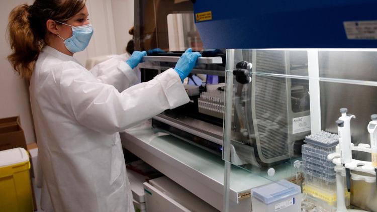 A laboratory technician prepares the machine to process the coronavirus analysis in a French medical biology laboratory.