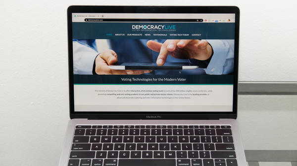 The Democracy Live homepage is displayed on a laptop.