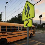 School bus at an intersection and children walking sign