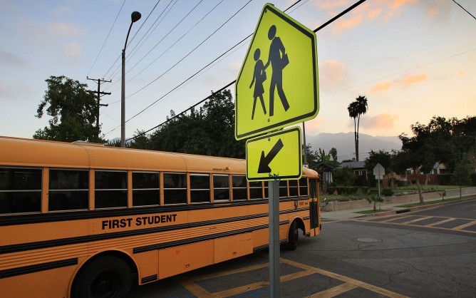 School bus at an intersection and children walking sign