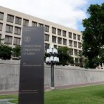 A blocky four-story building in the background. In front of it a sign reads United States Department of Labor