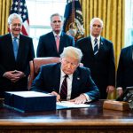 President Donald Trump signs the CARES Act in the oval office