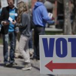 Electioneers greet voters outside the Hamilton County Government Center during early voting in Noblesville, Ind. in 2018.