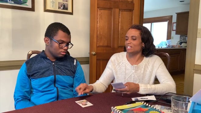 Malika Simmons and her son Eli, who has autism spectrum disorder and severe learning disabilities, work on a lesson together in their home.
