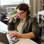 Woman in wheelchair on phone and laptop at home