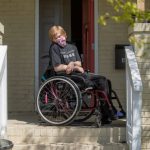 Janie Desmond who has visual impairment and mild intellectual disability comes to the edge of her porch for a portrait in Durham, N.C.