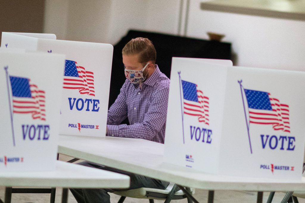 Man in mask casting his ballot