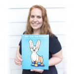 Gail Hamblin stands with her children’s book “More Alike Than Different.”