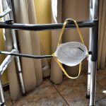 An N95 face mask rest on a walker device for assisting people with mobility issues