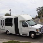 A white cutaway bus, which is about half as long as a standard bus