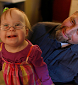 A man plays with his daughter who was born with Down syndrome.