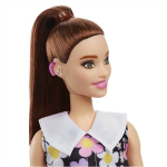 A Barbie doll with dark hair up in a ponytail with a hearing aid.