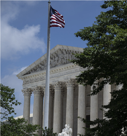 Exterior of the U.S. Supreme Court with flag.