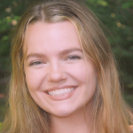 A close-up image of Ashley, who has long dark blonde hair and a broad smile.