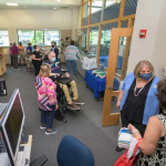 Small groups of people chat inside the new Kent/Sussex Assistive Technology Resource Center